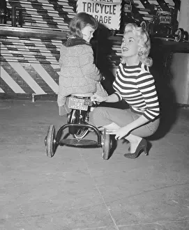 Prints of (Original Caption). Actress Jayne Mansfield adjusts the new 1956 license plate on the three wheeler of her 5 year old daughter, Jayne Marie, at a local tricycle garage A Glamorous Icon Unveiled: Jayne Mansfield Adjusting Her Daughter's License Plate