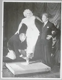 Prints of HARLOW, JEAN(HARLEAN CARPENTIER) 1911-37. AMERICAN ACTRESS SHOWN AT GRAUMAN'S CHINESE RESTAURANT. UNDATED PHOTO Rare prints capturing the allure of Hollywood's original blonde bombshell.: Jean Harlow Making Footprint at Grauman's Chinese Restaurant