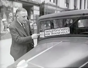 Jerome T. Harriman Pointing to Sticker on Car