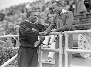 Prints of (Original Caption). Jesse Owens, (R), of Ohio State, wishes Ben Johnson of Columbia luck here, before the latter went out and won the 1st semi final of the 100 yard dash at the I.C.4.A A Legacy of Speed and Triumph: Jesse Owens Shaking Ben Johnson's Hand at Grandstands