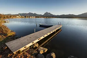 Jetty and rowing boat on the shore of Hopfensee Lake near Fuessen, Ostallgaeu region, Allgaeu, Bavaria, Germany, Europe