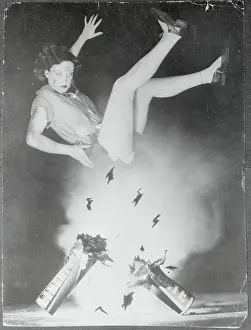 Prints of American actress Joan Crawford soars through the air as a firecracker explodes below her in the making of a Fourth of July picture A Glamorous Life Captured: Joan Crawford Blown in the Air from Firecracker Explosion