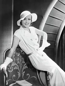 Prints of (Original Caption). White and Gold A Glamorous Life Captured: Joan Crawford Posing in White Dress