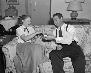 Joe DiMaggio Smoking with a Woman on Couch