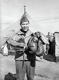 Joe Louis Holding Boxing Gloves and Shoes