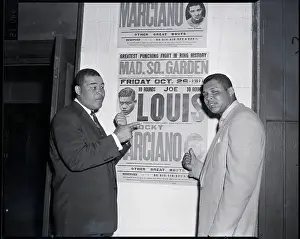 Joe Louis Points to Old Fight Poster