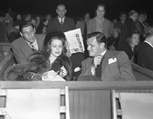 Joe Mankewicz and Loretta Young Sitting with Crowd Behind