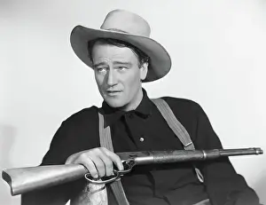 John Wayne Seated With Rifle