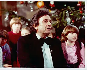 Prints of CIRCA 1975: Country singer/songwriter Johnny Cash in front of a Christmas tree surrounded by children in circa 1975. (Photo by Michael Ochs Archives/Getty Images) Iconic Images of The Voice of Country: Johnny Cash With Children