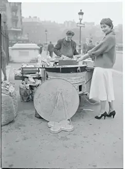 Prints of (Original Caption). Josiane Mariani Berenger, stepdaughter of a French fisherman, warms her hands over a chestnut vendor's fire while strolling the Paris boulevards alone The Iconic Moments Captured: Josiane Berenger Warming Her Hands
