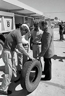 Prints of Argentine Formula One driver Juan Manuel Fangio (1911 - 1995) (left, in cap) talks with unidentified others about a tire during the Argentine Grand Prix, Buenos Aires, Argentina, January 29, 1973 Legends of the Track: Juan Manuel Fangio & Others At The Argentine Grand Prix