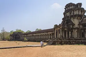 Married Prints: A Khmer couple from distance entering Angkor Wat Temple