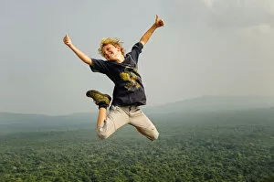 Images Dated 16th February 2014: A kid jumping above the forest