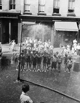 Splashing Prints: Kids under shower connected to hydrant, New York City, New York State, USA