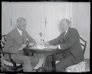 Prints of (Original Caption). Knute Rockne, coach of the Notre Dame team, signing a contract for Notre Dame Hockey Team to meet the Yale team at the Garden, being watched by Col. J Frozen Moments: A Journey Through Hockey History: Knute Rockne Signing Contract