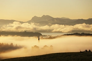 Break Of Dawn Gallery: Lake Chiemsee and the church steeple of Greimharting as seen from Ratzinger Hoehe in the early