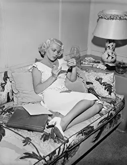 Lana Turner Inspects Photos Of Herself
