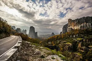 Thessaly Prints: Landscape of rugged cliffs, road, autumn foliage and Monastery Rousanou in the distance