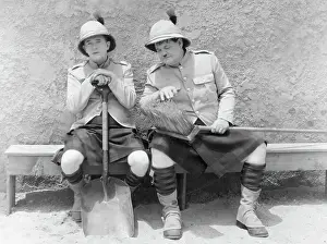 Prints of (Original Caption). Movie Still: Laurel and Hardy sitting on a bench with British Colonial uniforms on a bench with a shovel and broom Timeless Comedy Icons: Classic Moments from the Legendary Duo: Laurel And Hardy