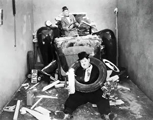 Prints of (Original Caption). Stan Laurel and Oliver Hardy crashing through the wall in their automobile. Still from a 1938 movie Timeless Comedy Icons: Classic Moments from the Legendary Duo: Laurel and Hardy in Movie Car Wreck