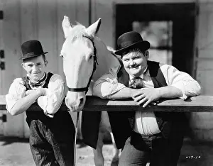 Prints of Publicity shot of comedians Stan Laurel, real name Arthur Stanley Jefferson (1890-1965) and Oliver Norvell Hardy (1892-1957) Timeless Comedy Icons: Classic Moments from the Legendary Duo: Laurel and Hardy Posing with Horse