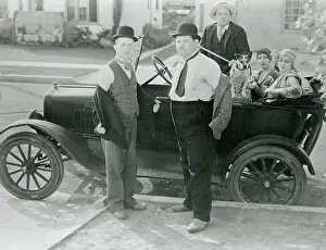 Prints of (Original Caption). Stan Laurel and Oliver Hardy is seen here taking off their jackets in preparation for a fight while Kay Deslys, Isabella Keep, and Edgar Kennedy sit in a car watching angrily Timeless Comedy Icons: Classic Moments from the Legendary Duo: Laurel and Hardy Standing by Car