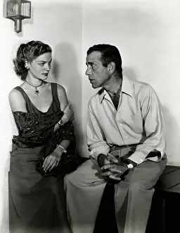 Prints of (Original Caption). Ca. 1940-1957-Lauren Bacall and Humphrey Bogart seated, together. She wears an evening gown. He wears a silk shirt and pants The Essence of Cool: Lauren Bacall W/Humphrey Bogart Seated