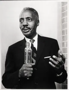 Program Prints: Leon Lewis Holding WLIB Microphone