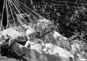 Prints of circa 1930: A chuckling baby spends a lazy day sitting in a hammock. (Photo by Chaloner Woods/Getty Images) Chaloner Woods Photography Prints: This Is The Life