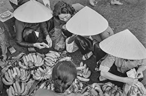 Prints of Vietnamese women, some wearing traditional non la hats, selling bananas on a street in Saigon, Vietnam, 30th August 1965 Vietnam Prints: Life In Saigon