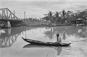 Prints of A person drifting in a sampan on the waters of an unspecified stretch of water in Saigon, Vietnam, 30th August 1965 Vietnam Prints: Life In Saigon