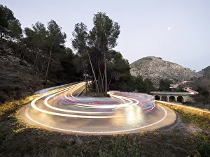 Headlight Prints: Lights of vehicles in movement circulating along a carretera with curves very closed in the moonlight