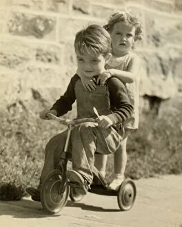 Images Dated 7th April 2016: Little boy giving little girl ride on tricycle