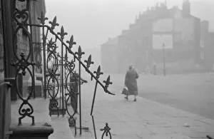 Railing Collection: Liverpool Streets; woman walking down a street in a slum area of Liverpool