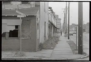 Lone Man Walking on Deserted Sidewalk