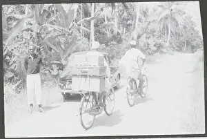 Zanzibar Prints: Lone Traveler with Car and Refugee Bicyclists Passing on Highway
