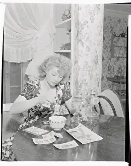 Prints of (Original Caption). Lucille Ball is shown at her home Behind the Laughter: Lucille Ball's Unseen Moments: Lucille Ball Helping to Prepare Cloth from Pattern