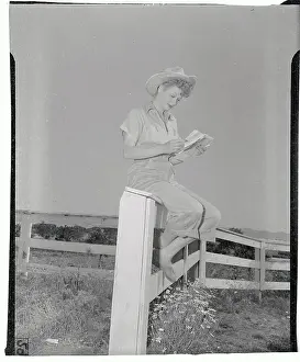 Prints of (Original Caption). Lucille Ball is shown at her home Behind the Laughter: Lucille Ball's Unseen Moments: Lucille Ball Sitting on Fence and Reading
