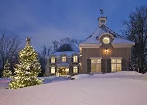 Images Dated 14th January 2012: Luxurious residential cottage style home with illuminated evergreen trees at dusk in winter