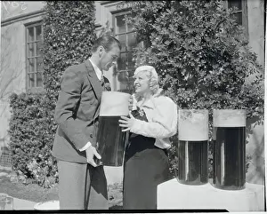 Mae West and Gary Cooper with Large Containers of Beer