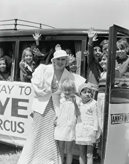 Mae West Posing with Orphans by Circus Bus