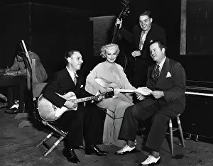 Mae West Sitting with Guitar and Musicians