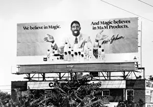 Prints of A portrait of basketball player Magic Johnson on a large billboard, advertising products with the slogan We believe in Magic, 1985. (Photo by Afro American Newspapers/Gado/Getty Images) Courtside Vibes: Stunning Basketball Prints: Magic Johnson Ad