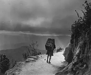 Challenge Prints: Magic Mountain; A heavily-burdened Nepalese labourer plods along a mountain track