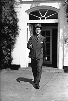 Mailman in front of house, (B&W)