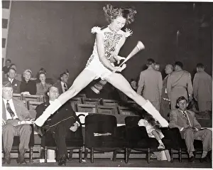 Majorette Jumping While Twirling Baton