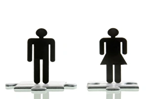 Male figure and a female figure standing on jigsaw puzzle pieces Male figure and a female figure standing on jigsaw puzzle pieces
