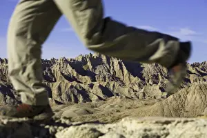 Focus On Background Prints: Male hiker walking in badlands, low section (focus on rock formations)