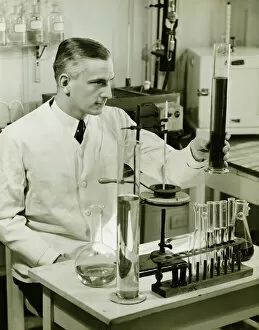 35 39 Years Gallery: Male pharmacist working with test tubes in laboratory, (B&W)