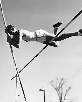 Male pole-vaulter clearing bar
